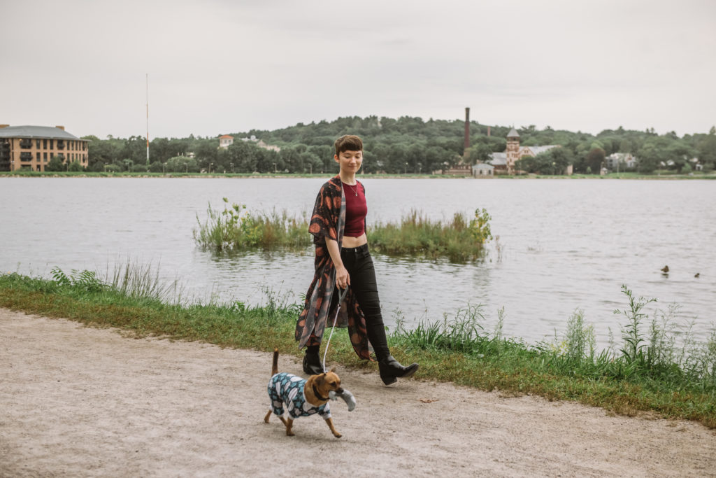 Danielle & Milo, wearing celestial outfits, walking along a path near water towards the camera.