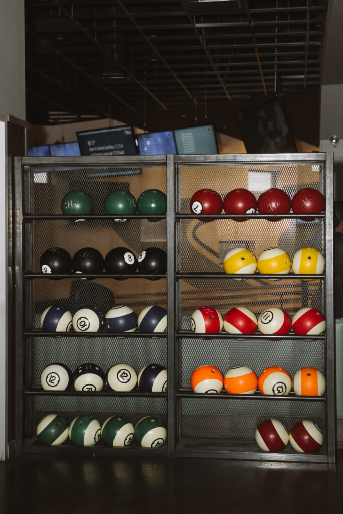 Bowling ball case from the front, featuring multiple bowling balls of different colors and numbers. 