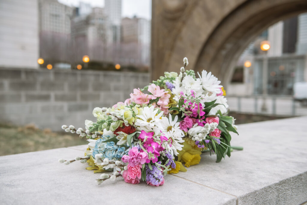 2 multicolored wedding bouquets on a concrete wall